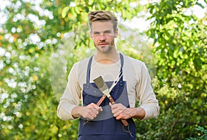 Barbeque party. Picnic concept. Bbq chef. Handsome guy cooking food. Cooking burgers. Man hold barbeque equipment