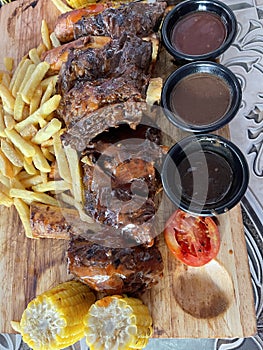 Barbeque ribs with great sauces and corns and frenchfries