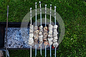 Barbeque skewers with meat rotating and cooking on the grill out