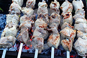 Barbeque skewers with meat rotating and cooking on the grill out