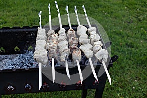 Barbeque skewers with meat rotating and cooking on the grill out