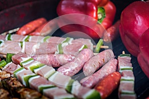 Barbeque with skewers, sausages and red peppers