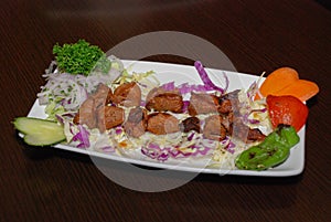 Barbequed lamb meat with salad on the white plate