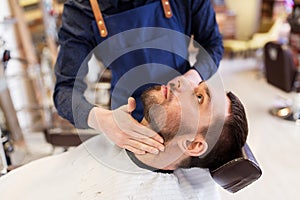 Barber applying aftershave lotion to male neck photo