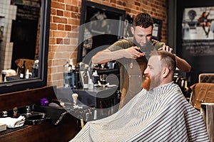 Barber and bearded man in barber shop