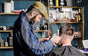 Barber with clipper trimming hair of client, rear view. Barber with hair clipper works on short haircut on nape