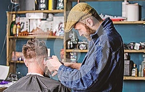 Barber with clipper trimming hair of client, rear view. Barber with hair clipper works on short haircut on nape