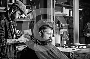 Barber with clipper trimming hair on nape of client. Hipster client getting haircut. Barber with hair clipper works on