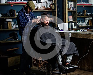 Barber with clipper trimming hair on nape of client. Hipster client getting haircut. Hipster style concept. Barber with