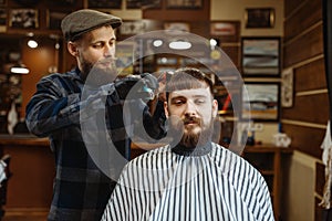 Barber with comb and scissors makes a haircut