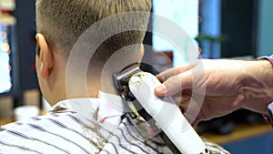 Barber cuts the boy`s hair. The process of forming a haircut close-up.