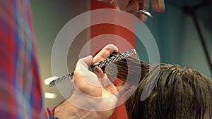 Barber cuts the boy`s hair. The process of forming a haircut close-up.