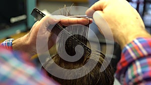 Barber cuts the boy`s hair. The process of forming a haircut close-up.