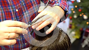 Barber cuts the boy`s hair. The process of forming a haircut close-up.