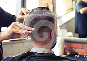 Barber cutting hair with scissors