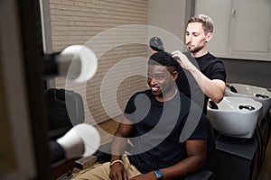 Barber dries a clients hair with a professional hair dryer