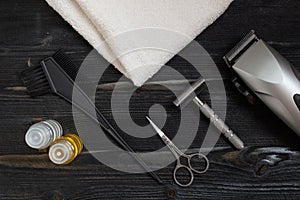 Barber equipment for home and barber shop. Top view of a shaving kit, soap and a scissors lying on a wooden surface with a white t