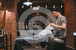 Barber finishing grooming and taking care of client's face