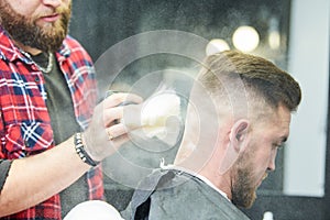 Barber or hair stylist at work. Hairdresser using talc