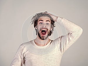Barber and hairdresser, male fashion. Sleepy man with beard on grey background. Uncombed hair. Man with disheveled hair