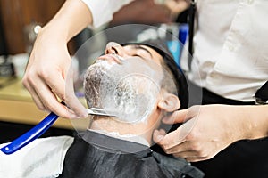 Barber Hands Shaving Man`s Stubble With Straight Razors