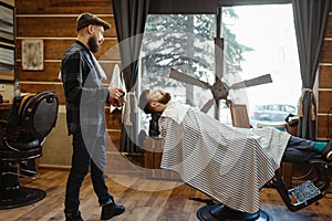 Barber in hat and bearded customer, beard cutting