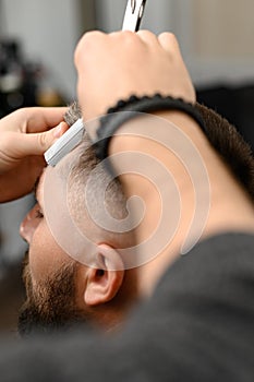 The barber makes the outline with a dangerous razor the undercut haircut