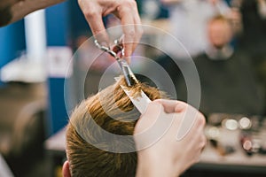 Barber Making Haircut Bearded Man In Barbershop. Professional stylist cutting client hair in salon. Barber using