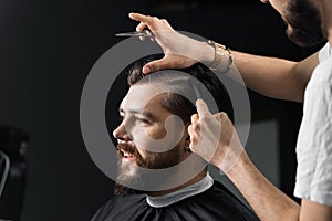 Barber making hairstyle for confident bearded hipster. Advertising for barbershop and men& x27;s beauty salon.