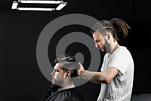 Barber making hairstyle for confident bearded hipster. Advertising for barbershop and men& x27;s beauty salon.