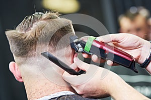 Barber making male haircut. Hairdresser cutting hair of client