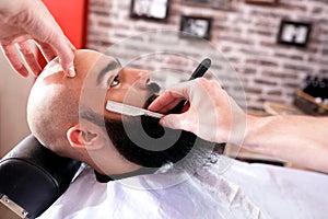 Barber a man in process of cutting beard