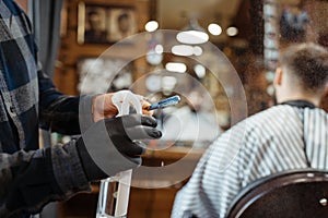 Barber processes the blade with spray, barbershop