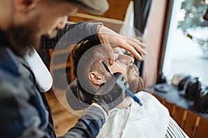 Barber with razor, old school beard cutting