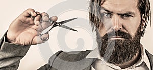 Barber scissors. Bearded man isolated on gray background. Mans haircut in barber shop. Barber scissors, barber shop