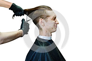 Barber scissors hair on the sides for a stylish long-haired guy in the barbershop. Men`s fashion and style, isolated