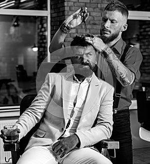 Barber scissors and straight razor. Razor sharp. Barber Shop Studios. Bearded man getting haircut by hairdresser and