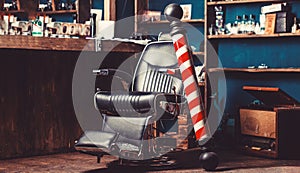 Barber shop pole. Logo of the barbershop, symbol. Stylish vintage barber chair. Hairstylist in barbershop interior