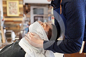 Barber softening male face sking with hot towel photo