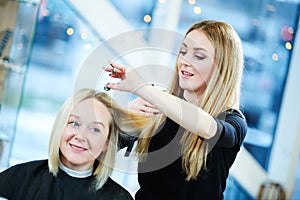 Barber or stylist at work. Hairdresser cutting woman hair