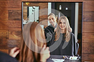 Barber talks to the young beautiful girl in a beauty salon photo