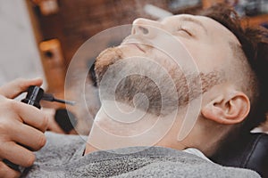Barber treats male skin with talcum powder and lotion for wounds and irritation after shaving beard with razor