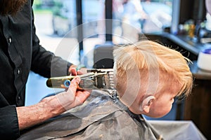 Barber using comb and shaver to cut hair.