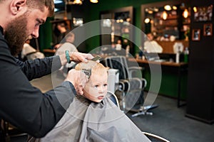 Barber using comb and shaver to cut hair.