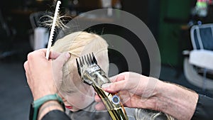 Barber using comb and shaver to cut hair.