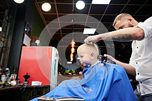 Barber using comb and shaver to cut hair.