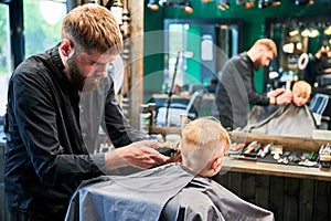 Barber using comb and shaver to cut hair.