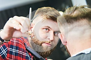 Barber at work. Hairdresser cutting hair of client
