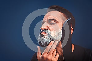 Barbershop background with brutal shaving with machete of bearded man