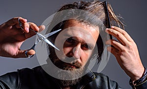 Barbershop. Bearded man with barber comb and scissors. Salon for men. Hairdresser.